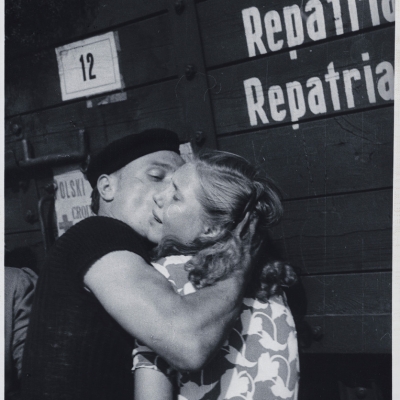 Julia Pirotte, "Farewell, station in Lille", ca. 1945, black-and-white photograph (negative), from the collection of Muzeum Sztuki in Łódź: In a half-figure shot, there is a man at the train station saying goodbye to a crying woman. He is hugging her and kissing her cheek.