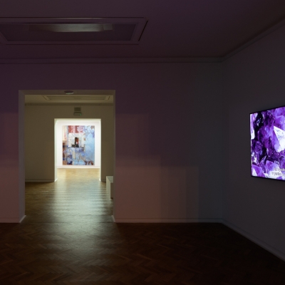 Widok na wystawę "Zwichnięty czas", fot. A. Zagrodzka: widok na wystawę, po prawej stronie na ścianie wisi telewizor.  A po lewej stronie jest łuk przez który widnieją się inne przestrzenie