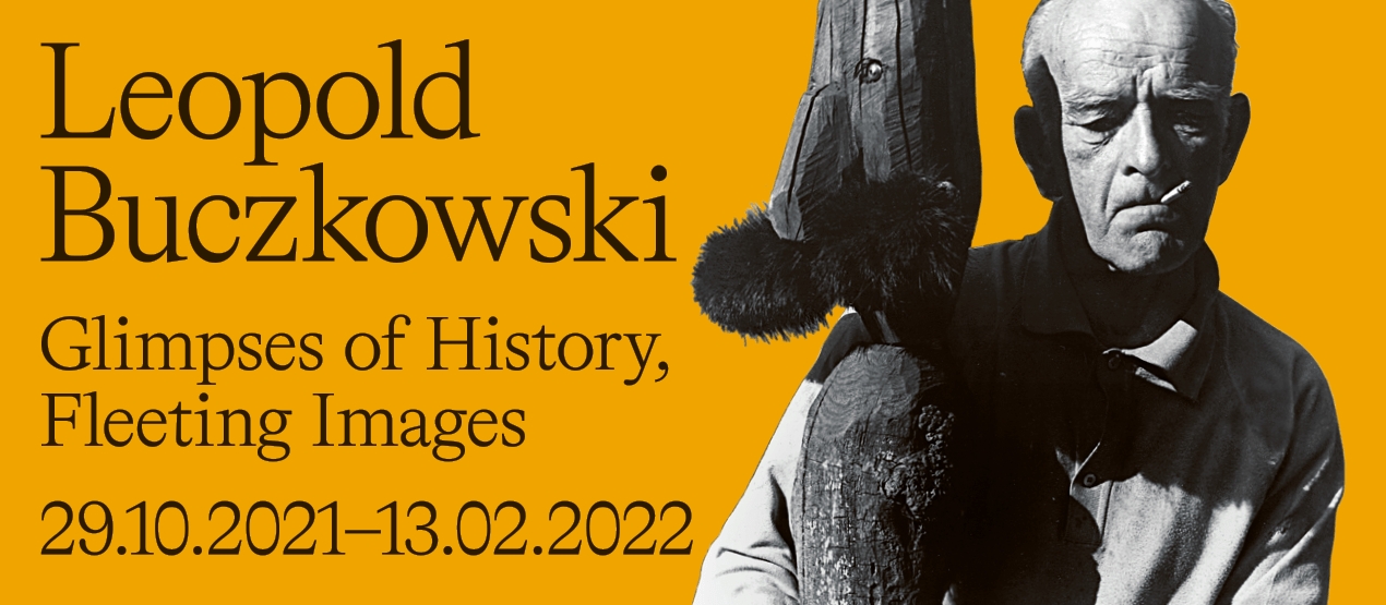 Grafika przedstawia Leopolda Buczkowskiego trzymające swoja rzeźbę, Obok napisy: Leopold Buczkowski Glimpses of History, Fleeting Images, od 29 października 2021 roku do 13 lutego 2022 roku