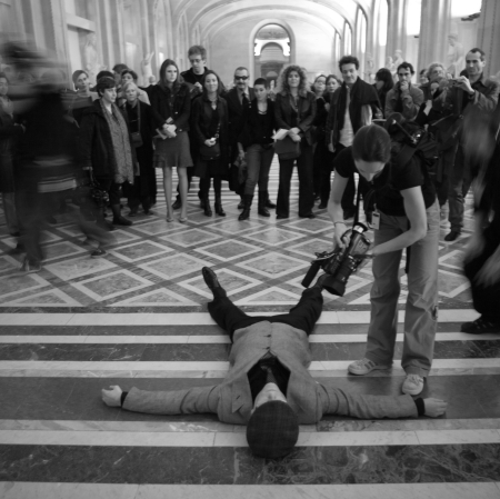 Man lying on the floor near pedestrian crossing, people around them