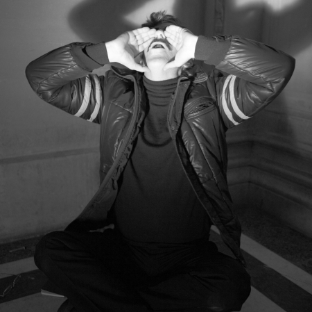 Man sitting on the floor raising his hands