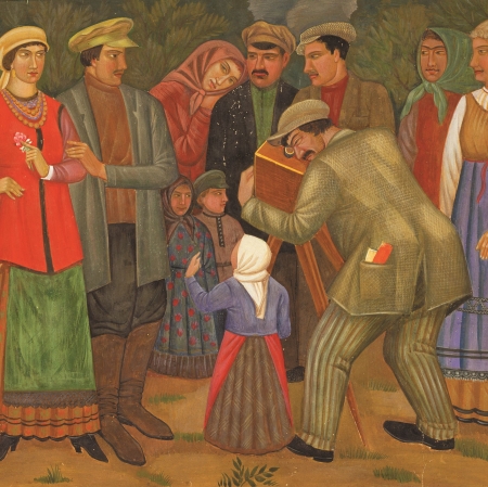 image, which shows a group of people standing in front of a camera operated by a photographer