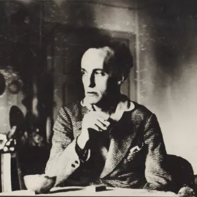 A black and white photo of a person sitting at a table