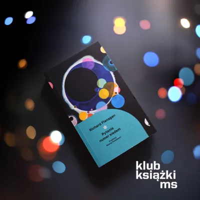 Książka Richarda Flanagana „Pytanie numer siedem” leży na ciemnym tle w otoczeniu kolorowych, rozmytych światełek. W prawym dolnym rogu znajduje się napis „klub książki ms”.