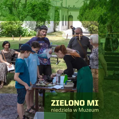 Zielony, prostokątny kształt, na którym znajduje się napis ZIELONO MI niedziela w Muzeum. Na środku grupa dzieci i dorosłych uczestniczy w plenerowych warsztatach plastycznych w ogrodzie.